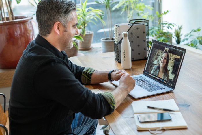 man conducting a zoom meeting with female employee as they prepare for another challenging year in 2022